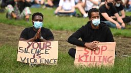 Protesters wearing protective face masks hold placards at a gathering in support of the Black Lives Matter movement on Woodhouse Moor in Leeds in northern England on June 21, 2020, in the aftermath of the death of unarmed black man George Floyd in police custody in the US. (Photo by Oli SCARFF / AFP) (Photo by OLI SCARFF/AFP via Getty Images)