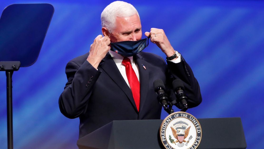 Vice President Mike Pence removes his mask to speak at the First Baptist Church Dallas during a rally on Sunday.