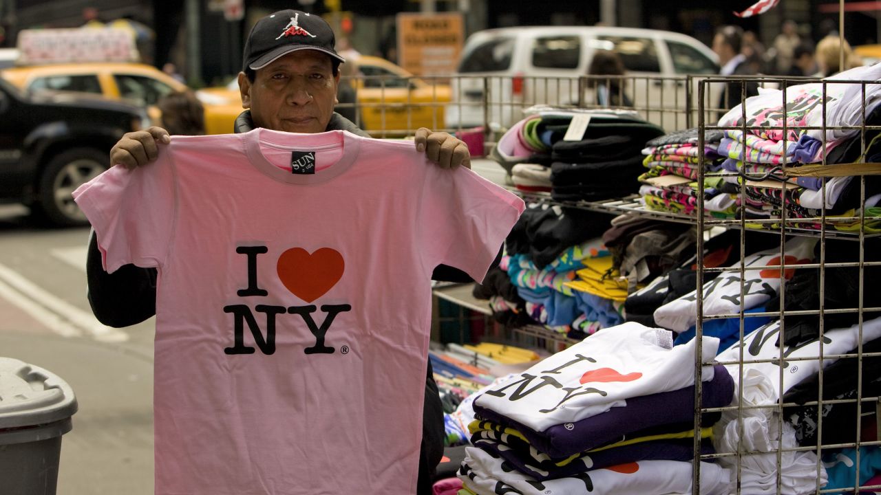A street vendor holds up an "I ♥ NY" t-shirt in 2009.