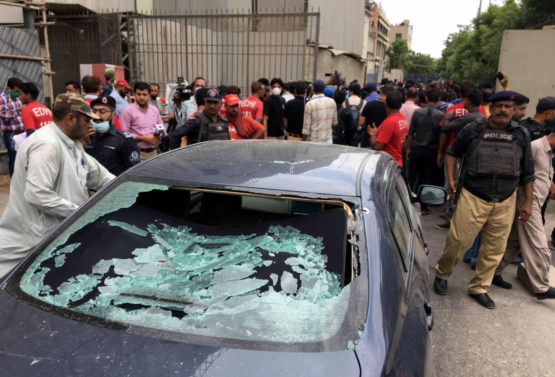 A plain clothes police officer (L) surveys the site of an attack at the Pakistan Stock Exchange entrance in Karachi on June 29, 2020. 