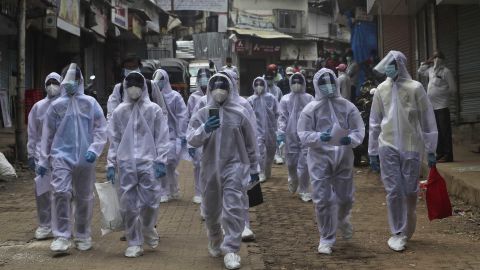 Health workers arrive at a medical camp in a slum in Mumbai, India on June 28