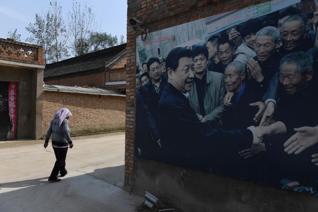 This photo taken in September 2017 shows A billboard featuring a photo of China's President Xi Jinping visiting residents in Zhangzhuang village in Lankao in China's central Henan province. 