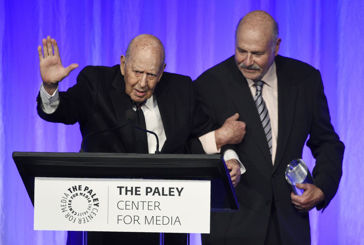Reiner, left, waves to the audience as he walks with his son Rob during the 2019 "Special Tribute to Television's Comedy Legends" event held by The Paley Center for Media in Beverly Hills.