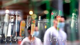 The reflection of pedestrians wearing facemeasks are seen as they walk past beer taps in a bar in Los Angeles on June 29, 2020 a day after the state's governor ordered the immediate closure of bars in a number of California counties, including Los Angeles County, due to rising spread of COVID-19 cases. - The coronavirus pandemic is "not even close to being over", the WHO warned today, as the global death toll passed half a million and cases surge in Latin America and the United States. (Photo by Frederic J. BROWN / AFP) (Photo by FREDERIC J. BROWN/AFP via Getty Images)