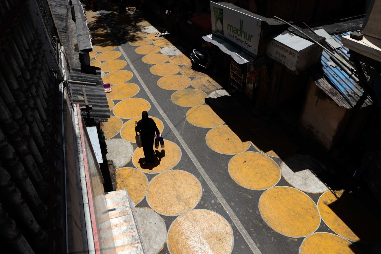 A woman walks along a road painted with circles to help people maintain social distancing in Mumbai, India, on June 29.