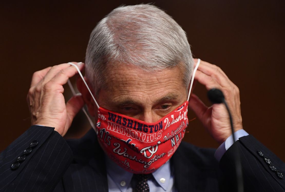 Dr. Anthony Fauci lowers his face mask as he prepares to testify before the Senate Health, Education, Labor and Pensions (HELP) Committee on Capitol Hill.