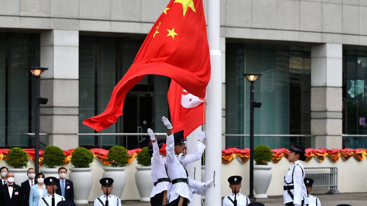 The Chinese (front) and Hong Kong flags are released during a flag-raising ceremony to mark China's National Day celebrations early morning in Hong Kong on July 1, 2020.