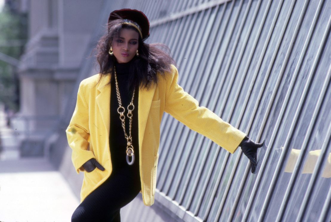 A model poses in a yellow jacket with exaggerated shoulders in 1980s New York.