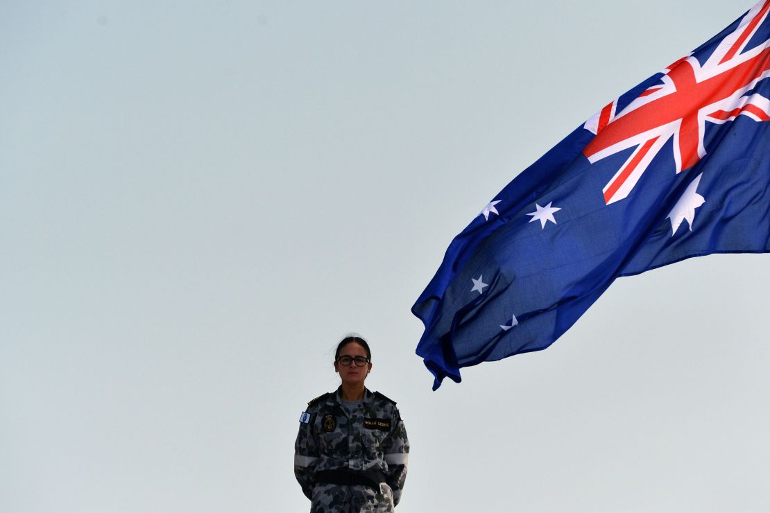 A Royal Australian Navy personnel stands next to the Australia's national flag as she takes part in training exercise in the Sri Lankan capital Colombo on March 26, 2019.