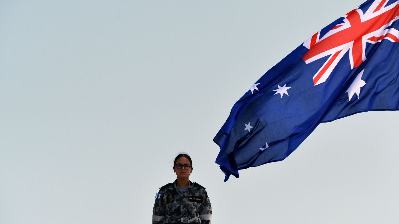 A Royal Australian Navy personnel stands next to the Australia's national flag as she takes part in training exercise in the Sri Lankan capital Colombo on March 26, 2019.