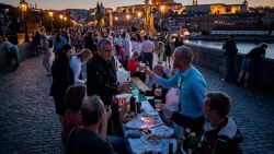 PRAGUE, CZECH REPUBLIC - JUNE 30: Residents sit to dine on a 500 meter long table set on the Charles Bridge, after restrictions were eased following the coronavirus pandemic on June 30, 2020 in Prague, Czech Republic. Some 2,000 seats are proposed with people being invited to bring and share food and drinks to welcome summer. The country has eased nationwide lockdown restrictions, although last week it reported 260 new coronavirus cases, its highest daily tally since April 8. (Photo by Gabriel Kuchta/Getty Images)