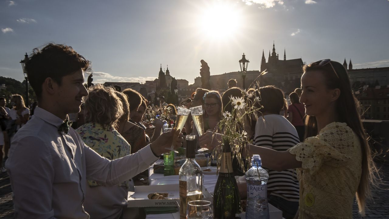 People dine at a communal table stretching across the Charles Bridge in Prague after coronavirus restrictions were eased on June 30, 2020.