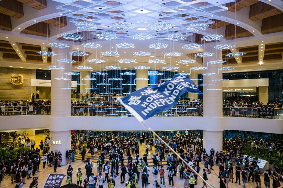 People wave flags and shout slogans inside a Hong Kong shopping mall on June 15.