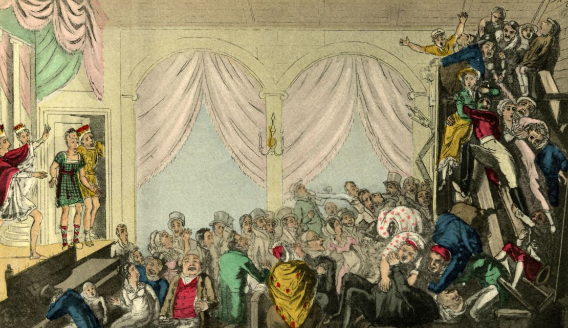 A riotious audience in the balcony during the  performance of a play in the early 19th century.