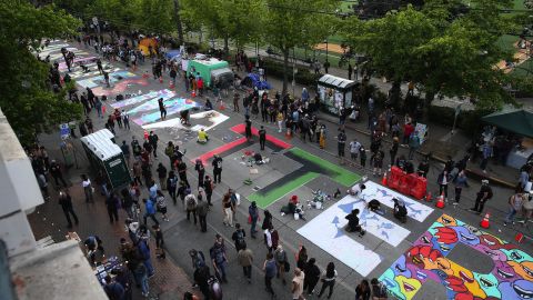 Artists paint a streetwide sign that says Black Lives Matter over several blocks on June 11 in the CHOP.