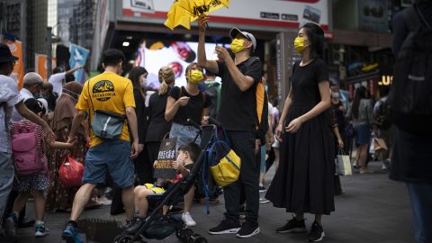 A family in Causeway Bay is seen with signs and yellow paraphernalia, the color of the pro-democracy movement.