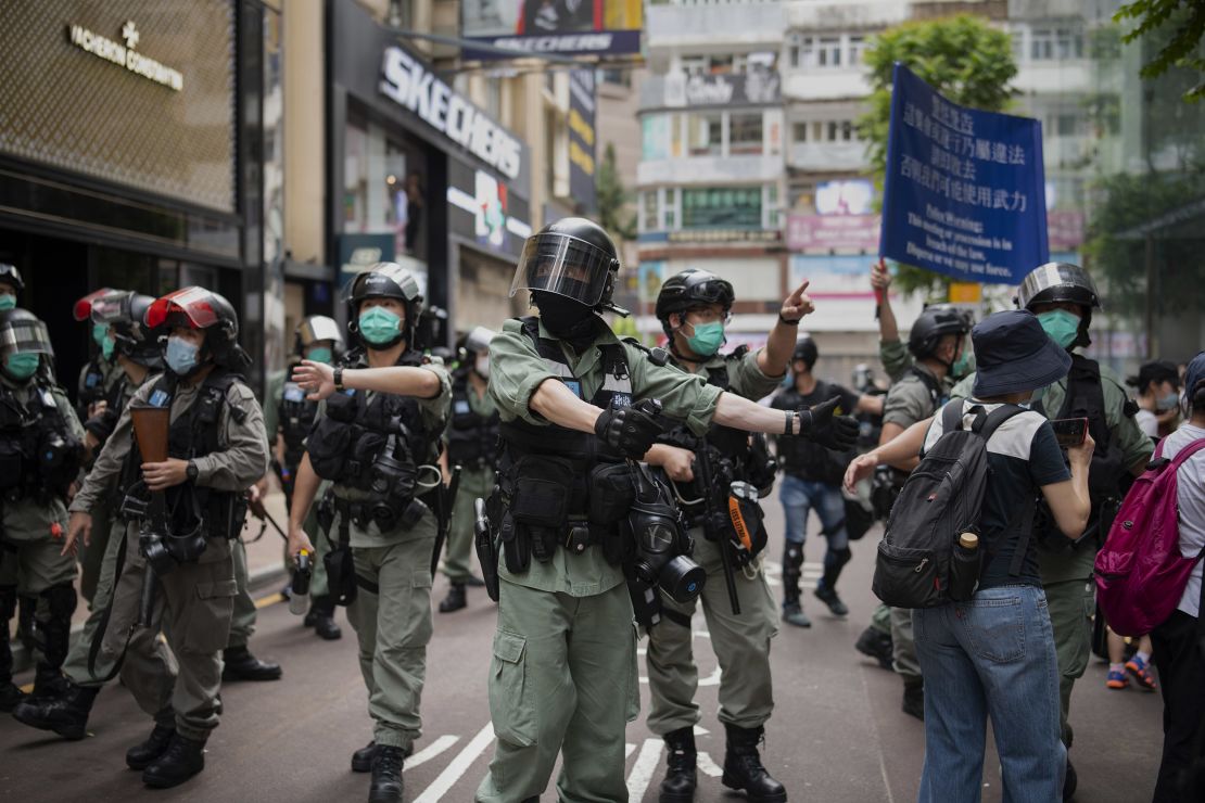 Police in riot gear are seen outside Hysan Place, an upscale shopping mall in Causeway Bay, ordering people to disperse.