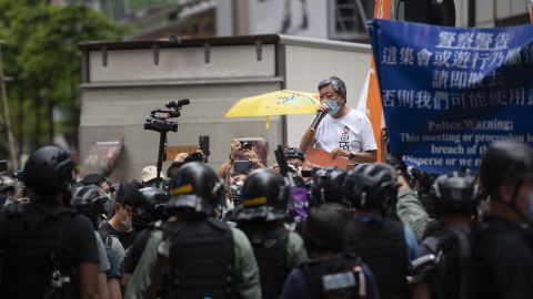Former lawmaker and longtime activist Lee Cheuk-Yan is seen addressing a crowd in Causeway Bay as riot police stand in the background. He was arrested soon after.