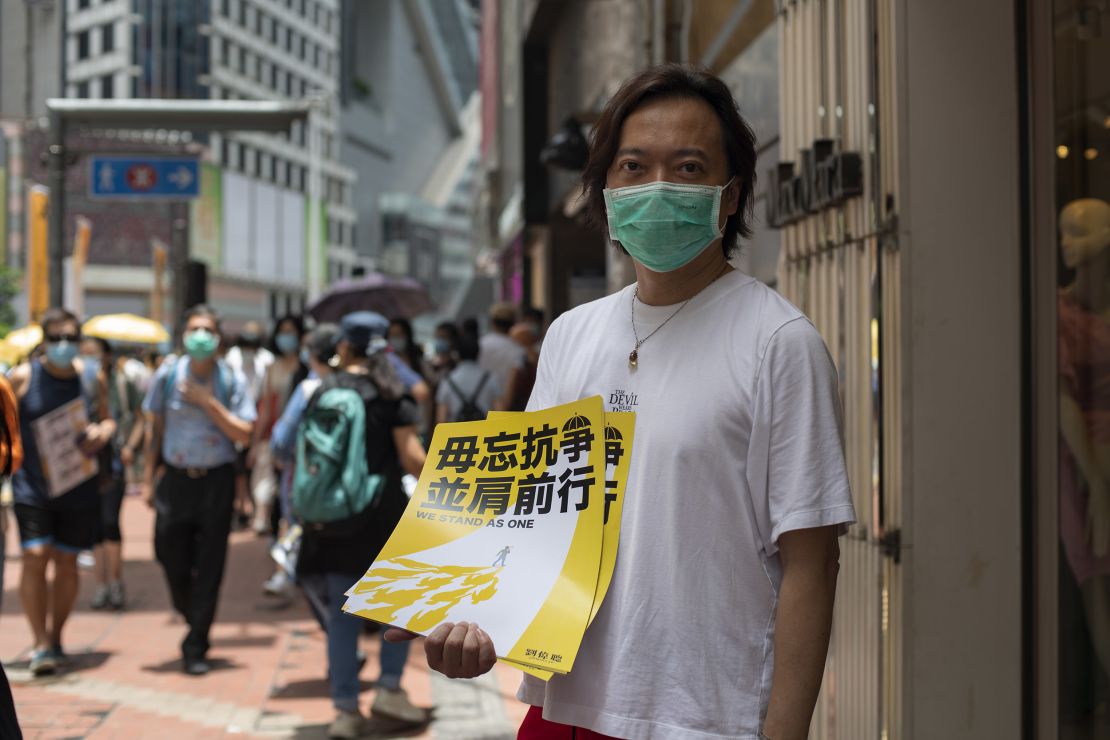 District Councilor and barrister Lawrence Lau holds up a poster in the Hong Kong district of Causeway Bay, shortly before police started clearing the area, on Wednesday.