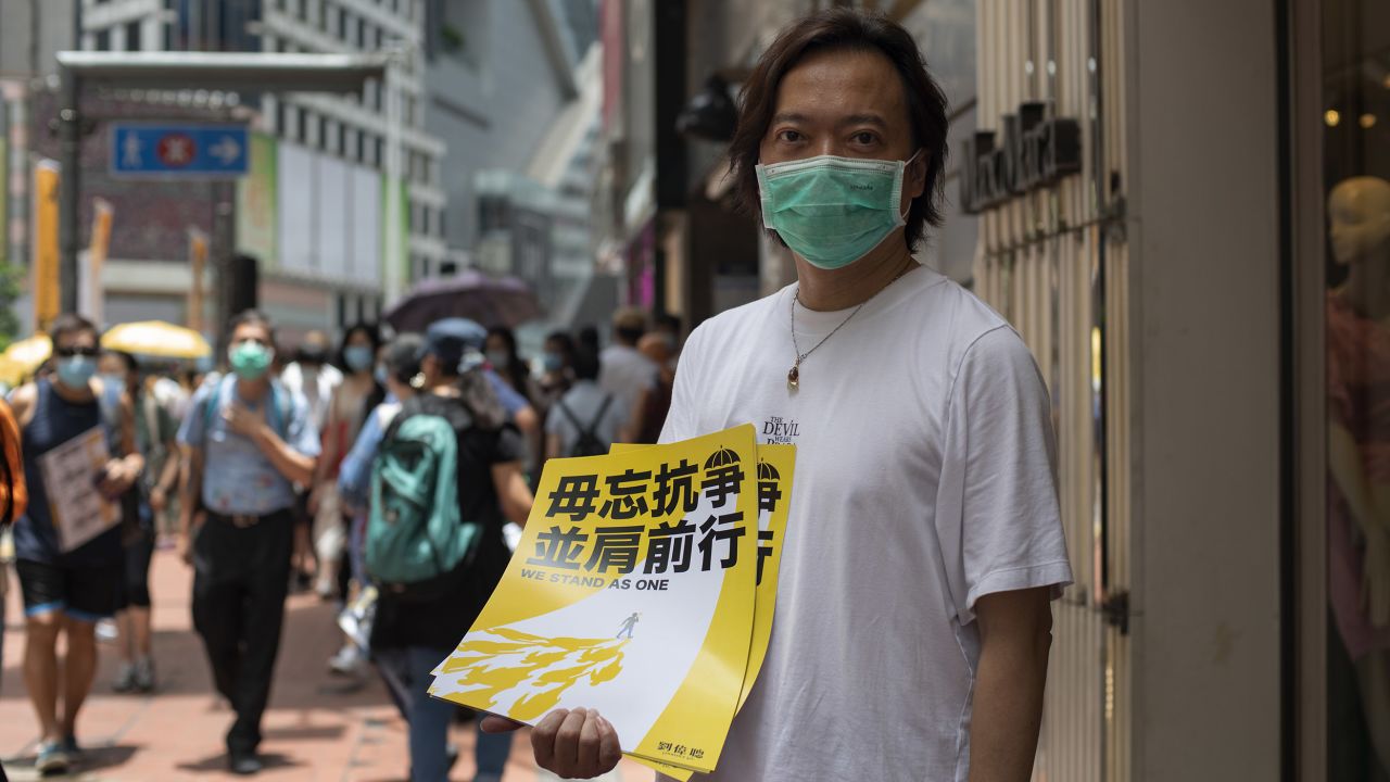 District Councilor and barrister Lawrence Lau holds up a poster in the Hong Kong district of Causeway Bay, shortly before police started clearing the area, on Wednesday.