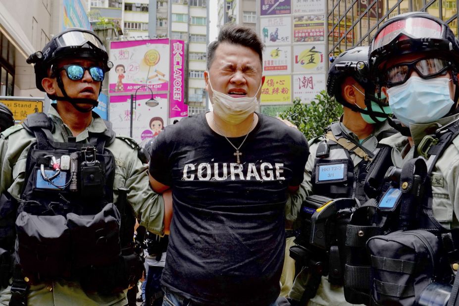 A protester is detained by police after being pepper sprayed during a protest at Causeway Bay before the annual handover march in Hong Kong, Wednesday, July 1. 