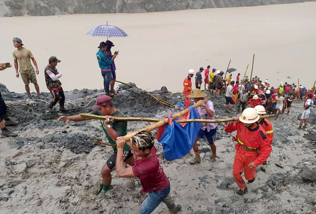 Rescue workers carrying the body of a victim after a landslide at a jade mining site in Myanmar. 