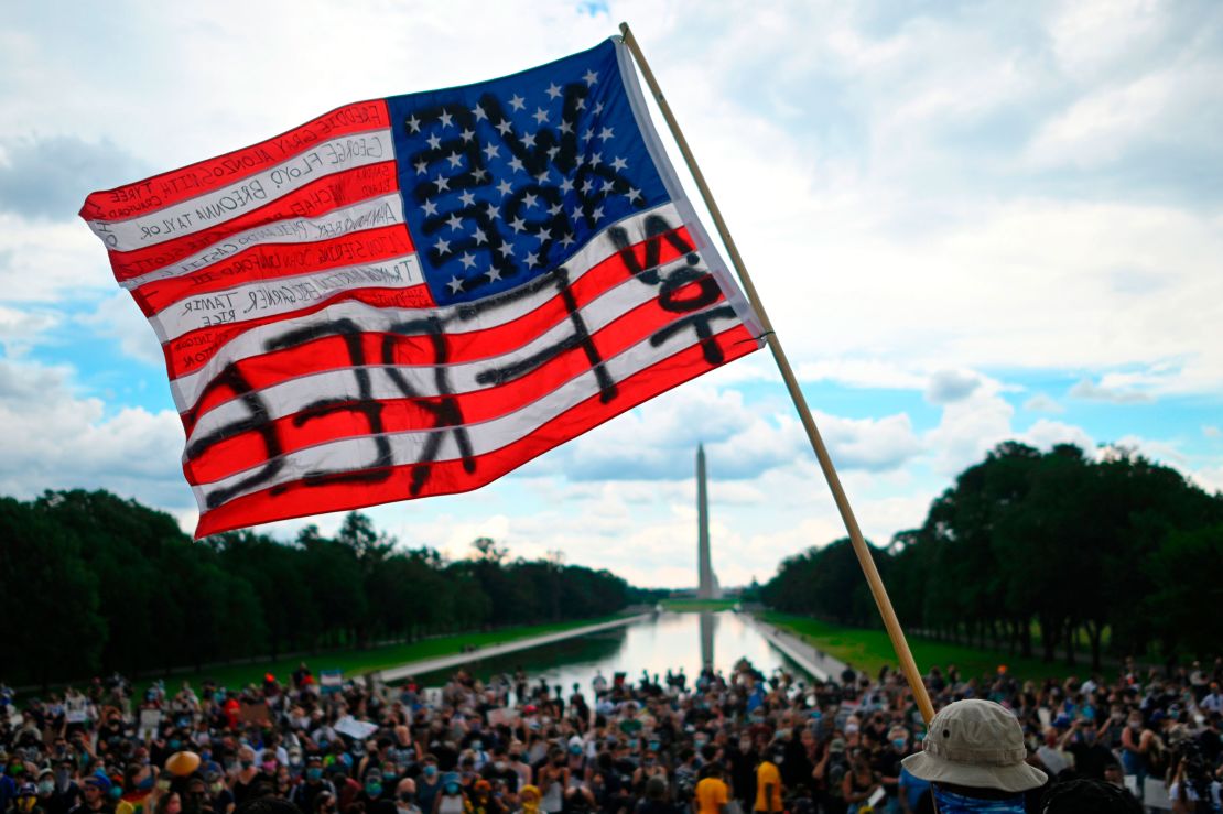 A man waves an American flag with the words "Not Free" on it at a Juneteenth rally in Washington on June 19, 2020.