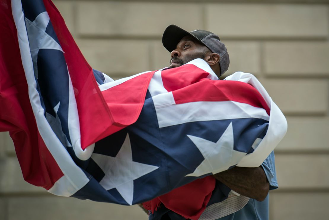 A staff member raises the state flag for the flag retirement ceremony at the Mississippi State Capitol building in Jackson, Mississippi on July 1, 2020. (Photo by Rory Doyle / AFP)
