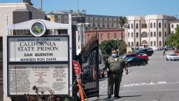 A California Department of Corrections and Rehabilitation (CDCR) officer wearing a protective mask stands at the front gate of San Quentin State Prison in San Quentin, California, U.S., on Tuesday, June 30, 2020. California Governor Gavin Newsom is working to release more than 3,500 prisoners who are close to finishing their sentences as Covid-19 tears through the states correctional system, including an outbreak that has infected nearly a third of inmates at San Quentin State Prison near San Francisco. Photographer: David Paul Morris/Bloomberg via Getty Images