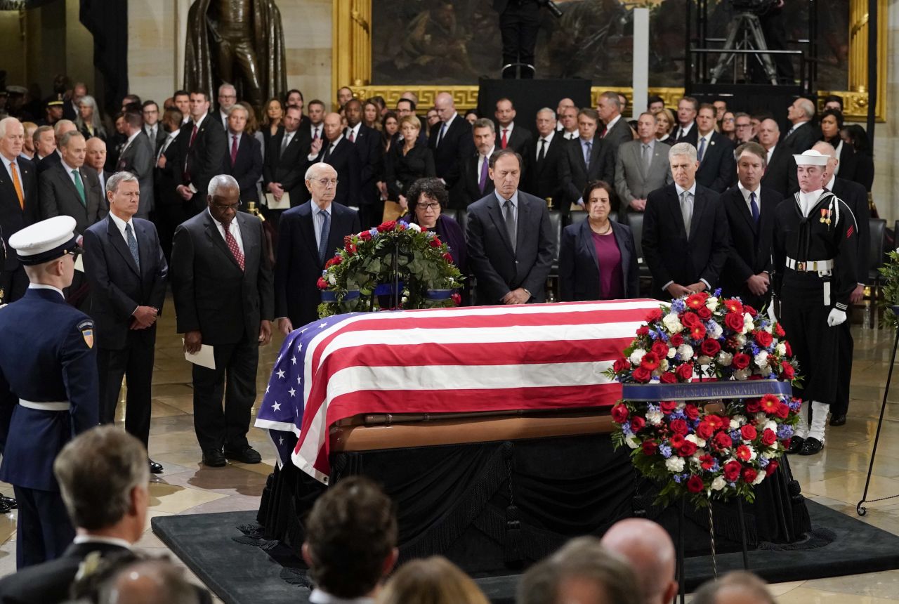 Members of the Supreme Court pause in front of the flag-draped casket of former President George H.W. Bush as he lies in state at the US Capitol Rotunda in 2018.