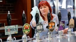 A member of staff at a Wetherspoons pub in north London cleans the bar in preparation for pubs to reopen early next month on June 24, 2020. - Prime Minister Boris Johnson yesterday announced a further easing of coronavirus restrictions in England from July 4, as part of plans to kickstart hospitality, culture and tourism. 
