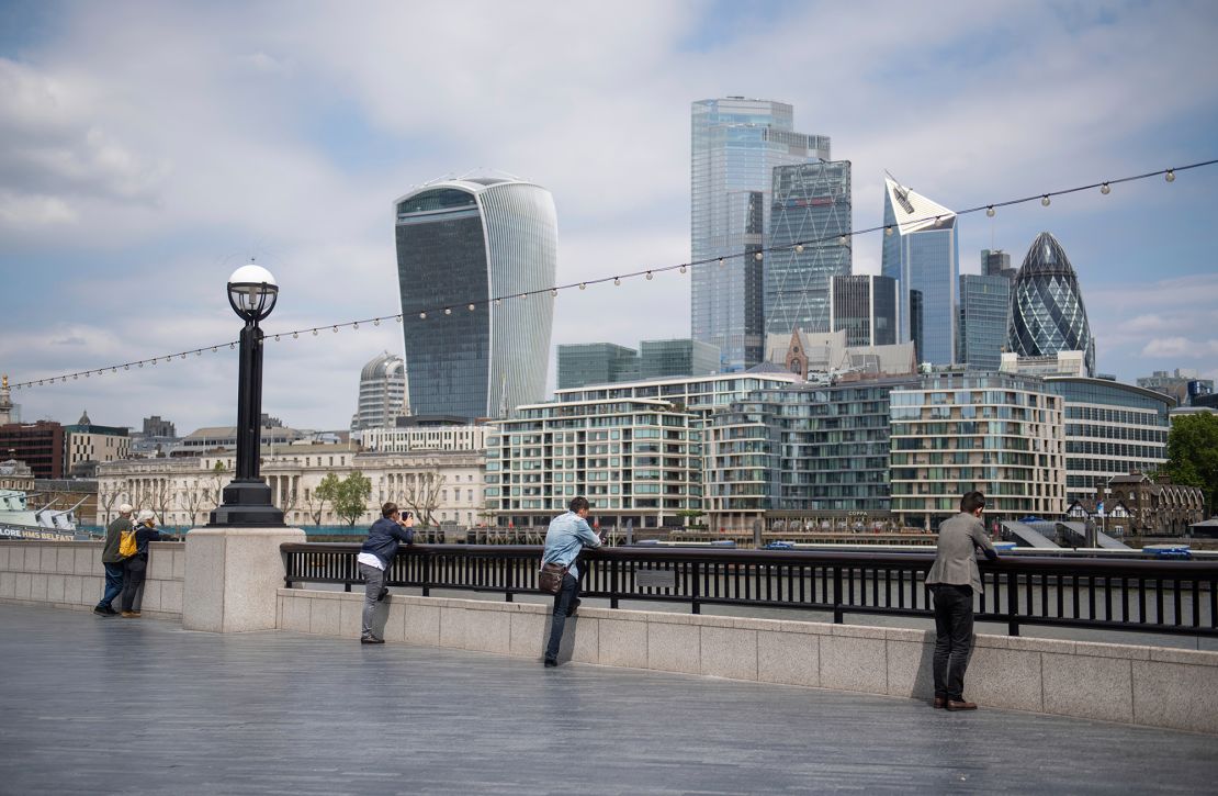 People observe social distancing as they look out at the skyline of London's financial district on June 9.