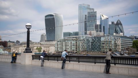 People observe social distancing as they look out at the skyline of London's financial district on June 9.