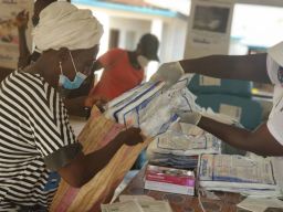 A Red Cross volunteer helps prepare packs of treated bed nets to be distributed to community members in Sierra Leone.