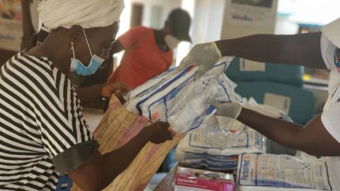 A Red Cross volunteer helps prepare packs of treated bed nets to be distributed to community members in Sierra Leone.