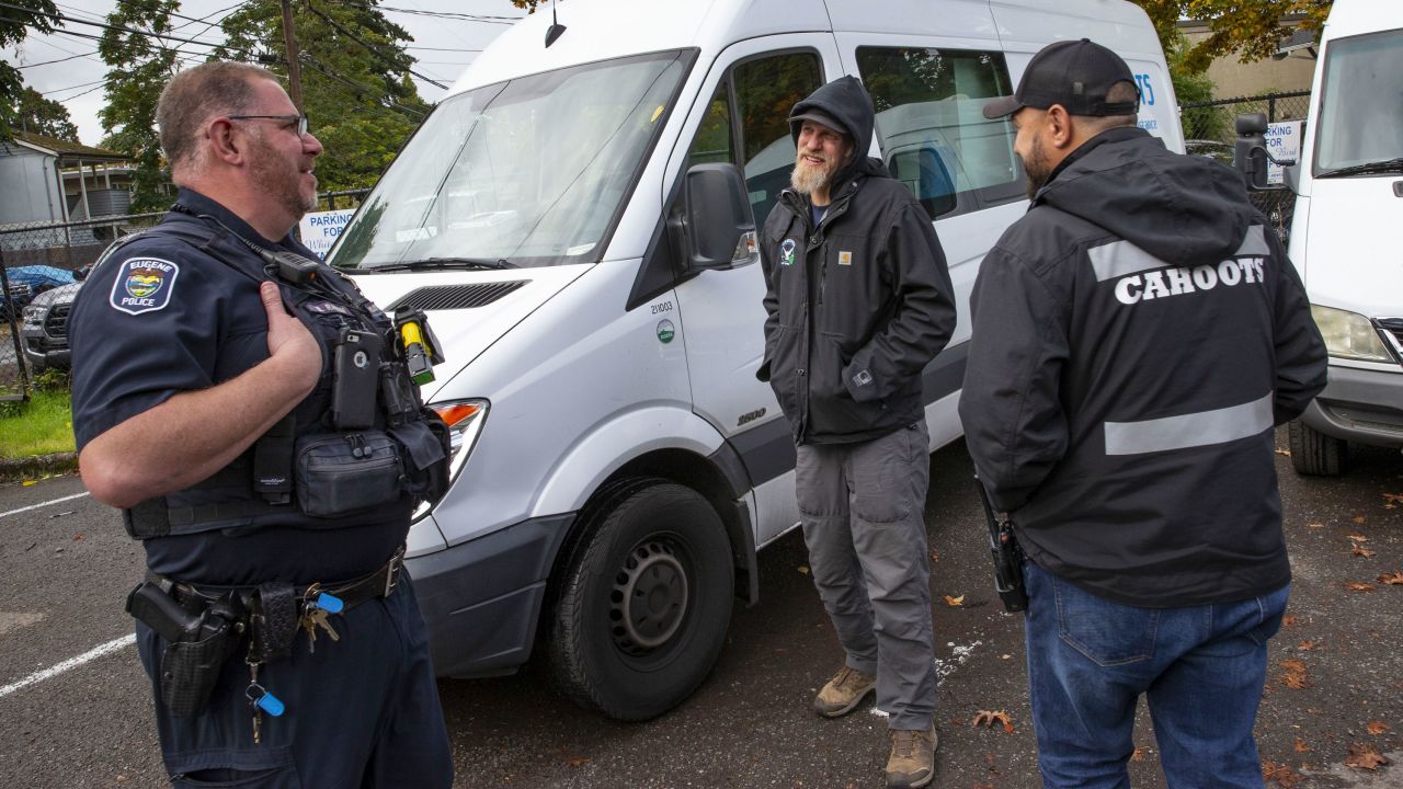 Eugene Police officer Bo Rankin, left, meets with Cahoots administrative coordinator Ben Brubaker and emergency crisis worker Matt Eads, right, after working a shift together as part of the Community Outreach Response Team in Eugene.   Mandatory Credit: Chris Pietsch/The Register-Guard via USA TODAY NETWORK