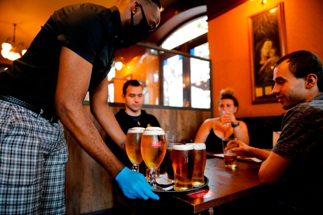 A member of staff serves customers at a pub in Stratford, east London.