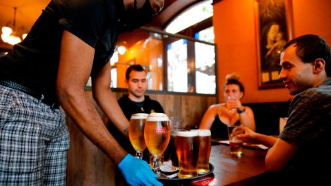 A member of staff serves customers at a pub in Stratford, east London.