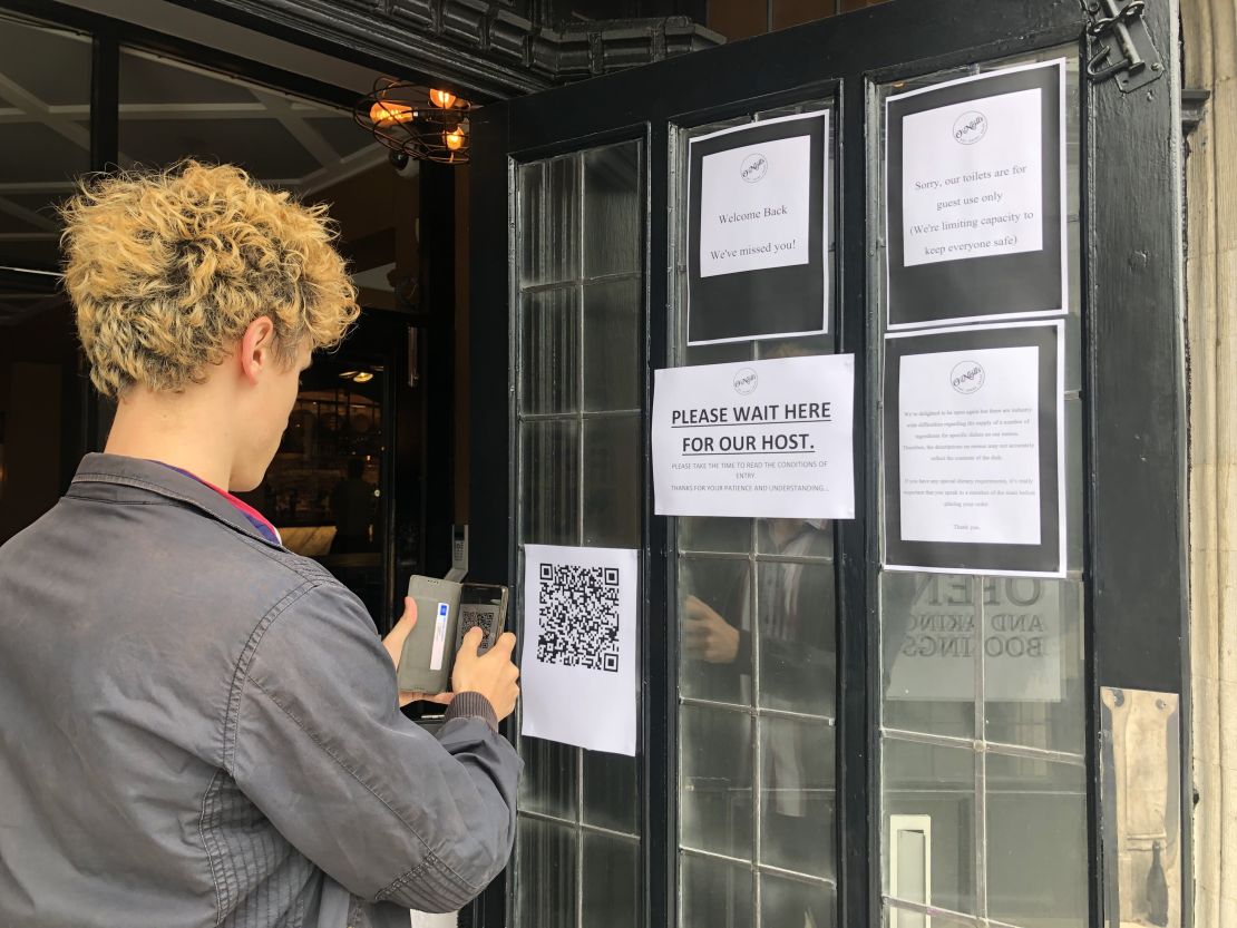 A drinker scans a QR code in order to enter contact-tracing details before entering a south London pub.