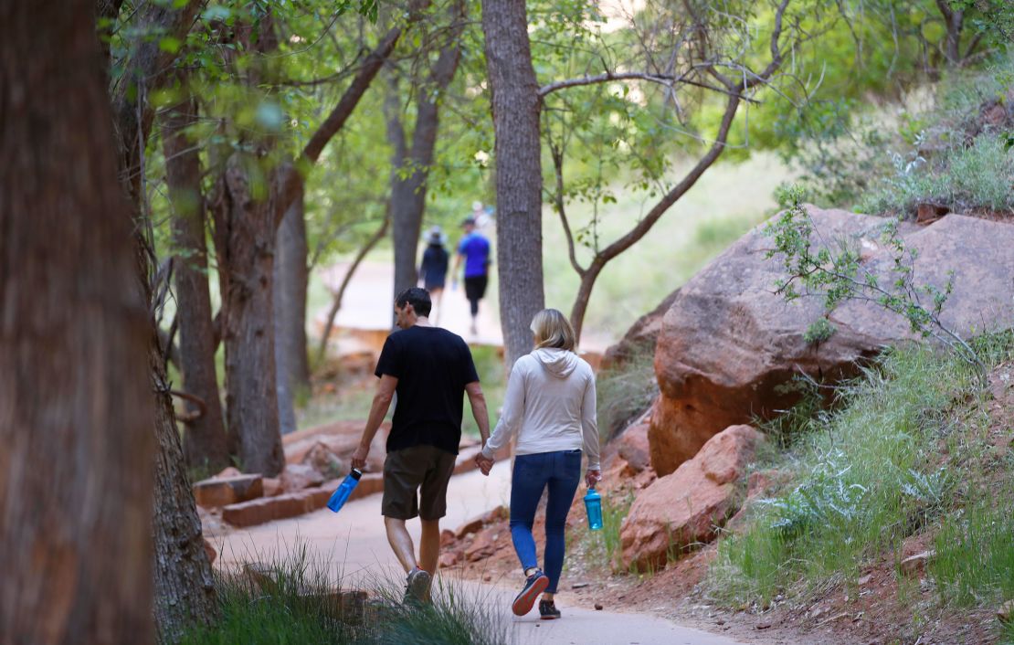 Hikers walking along a paved trail in Utah's Zion National Park, Utah, which had been closed due to the pandemic.