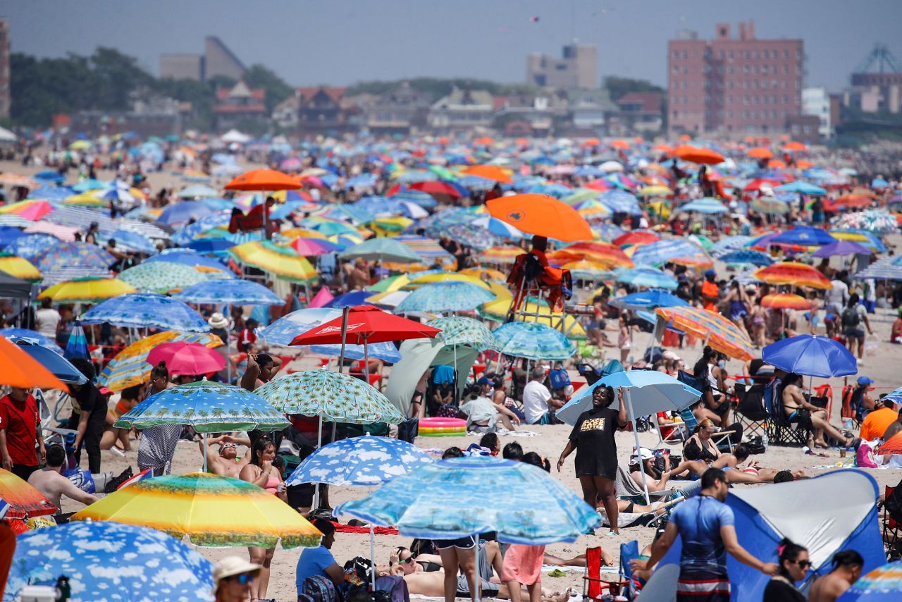 People crowd the beach at Coney Island in Brooklyn, New York.