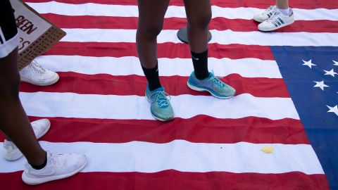 Demonstrators stand on an American Flag while protesting racial injustice at Black Lives Matter Plaza in Washington, DC.