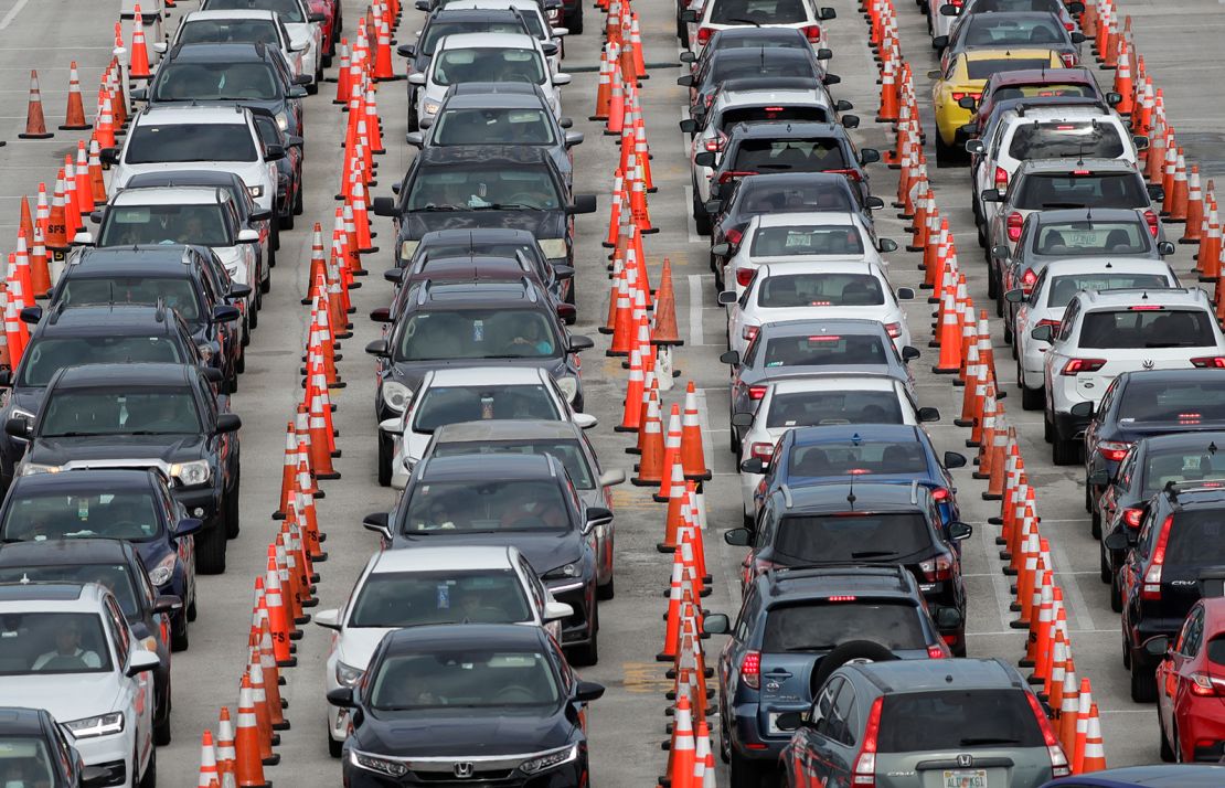 Cars wait at a drive-through coronavirus testing site Sunday in Miami Gardens.