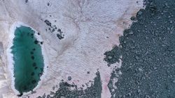 An aerial picture taken on July 3, 2020 above the Presena glacier near Pellizzano, shows pink colored snow, supposedly due to the presence of colonies of algae of the species Ancylonela nordenskioeldii from Greenland. (Photo by Miguel MEDINA / AFP) (Photo by MIGUEL MEDINA/AFP via Getty Images)