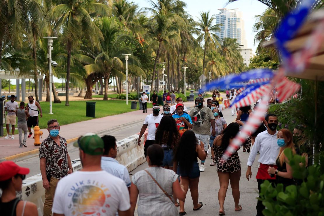 People walk past restaurants on Ocean Drive in Miami Beach on Friday. 
