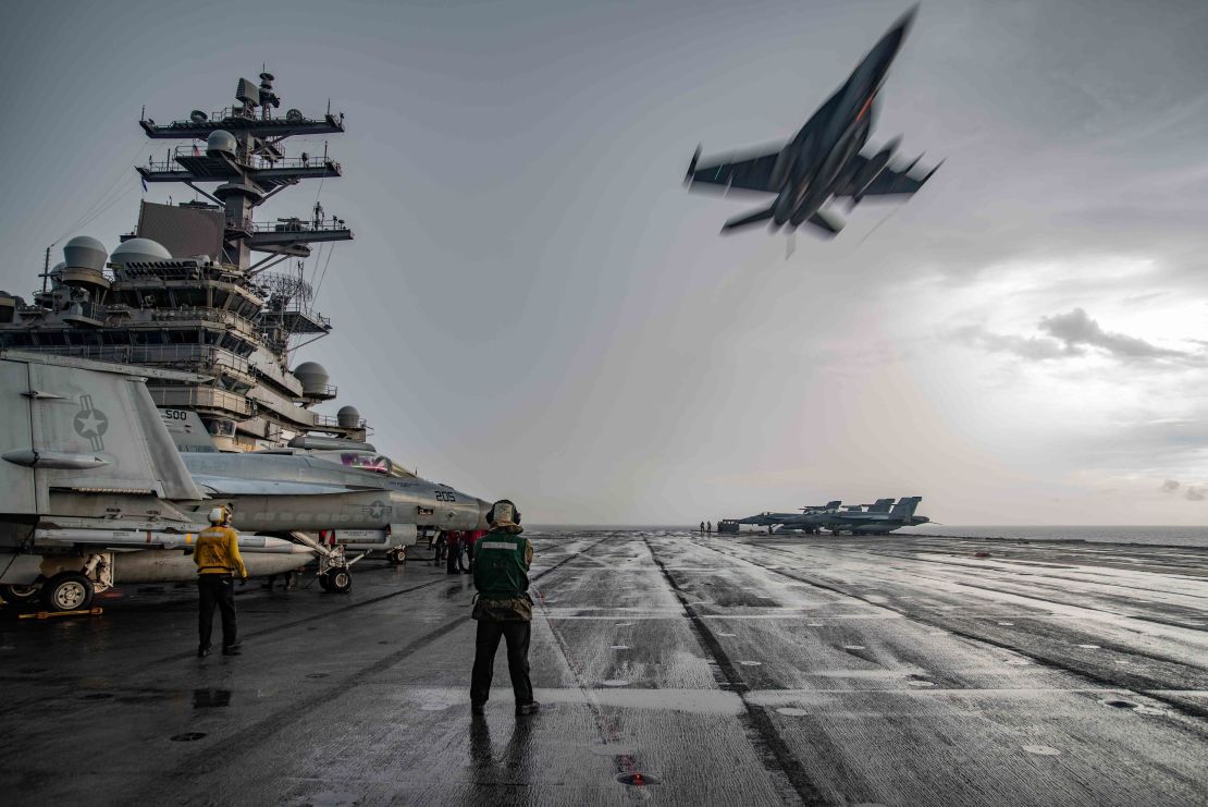 An F/A-18E Super Hornet flies over the flight deck of the USS Ronald Reagan in the South China Sea on July 4, 2020.