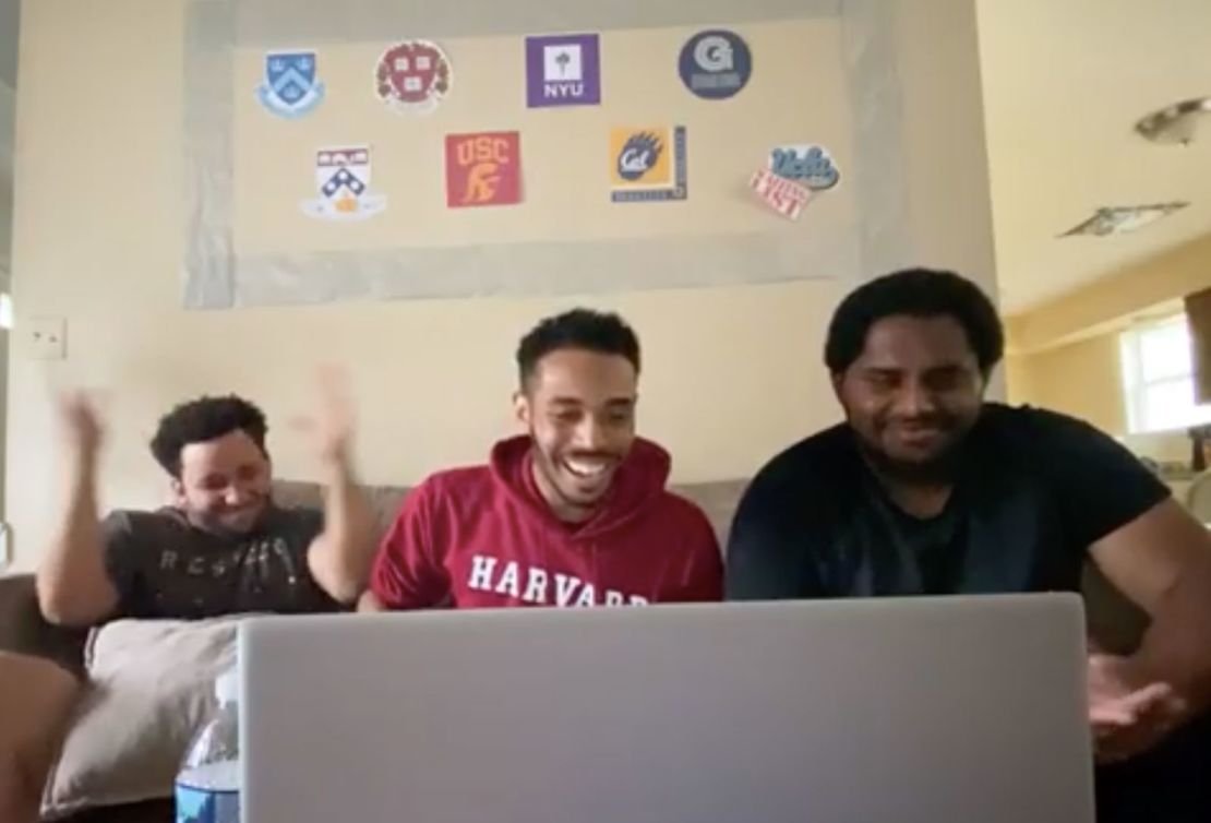 Rehan Staton, middle, with his cousin Dominic Willis, 24, left, and his brother, Reggie Staton, 27, at the moment he receives his acceptance to Harvard Law School. 