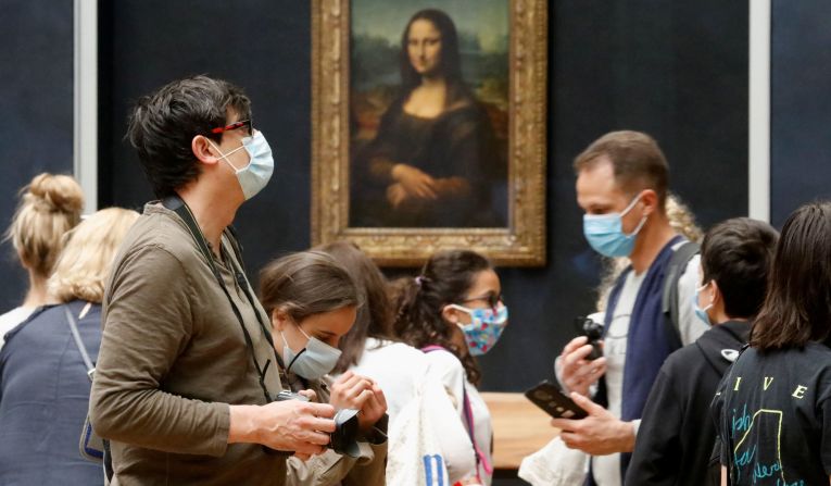 Visitors stand in front of the "Mona Lisa" at the Louvre in Paris on July 6. The Louvre, the world's most popular museum, <a href="index.php?page=&url=https%3A%2F%2Fwww.cnn.com%2Ftravel%2Farticle%2Flouvre-reopens-july%2Findex.html" target="_blank">has reopened its doors</a> after months of closure.