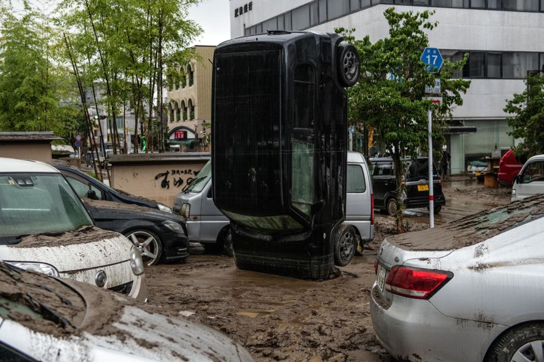 A car stands on its front after being upturned by flooding after the nearby Kuma River burst its banks, on July 5 in Hitoyoshi, Japan.