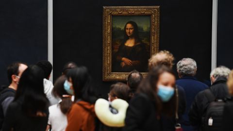 Visitors in masks queue up for a glimpse of the Mona Lisa at the Louvre.